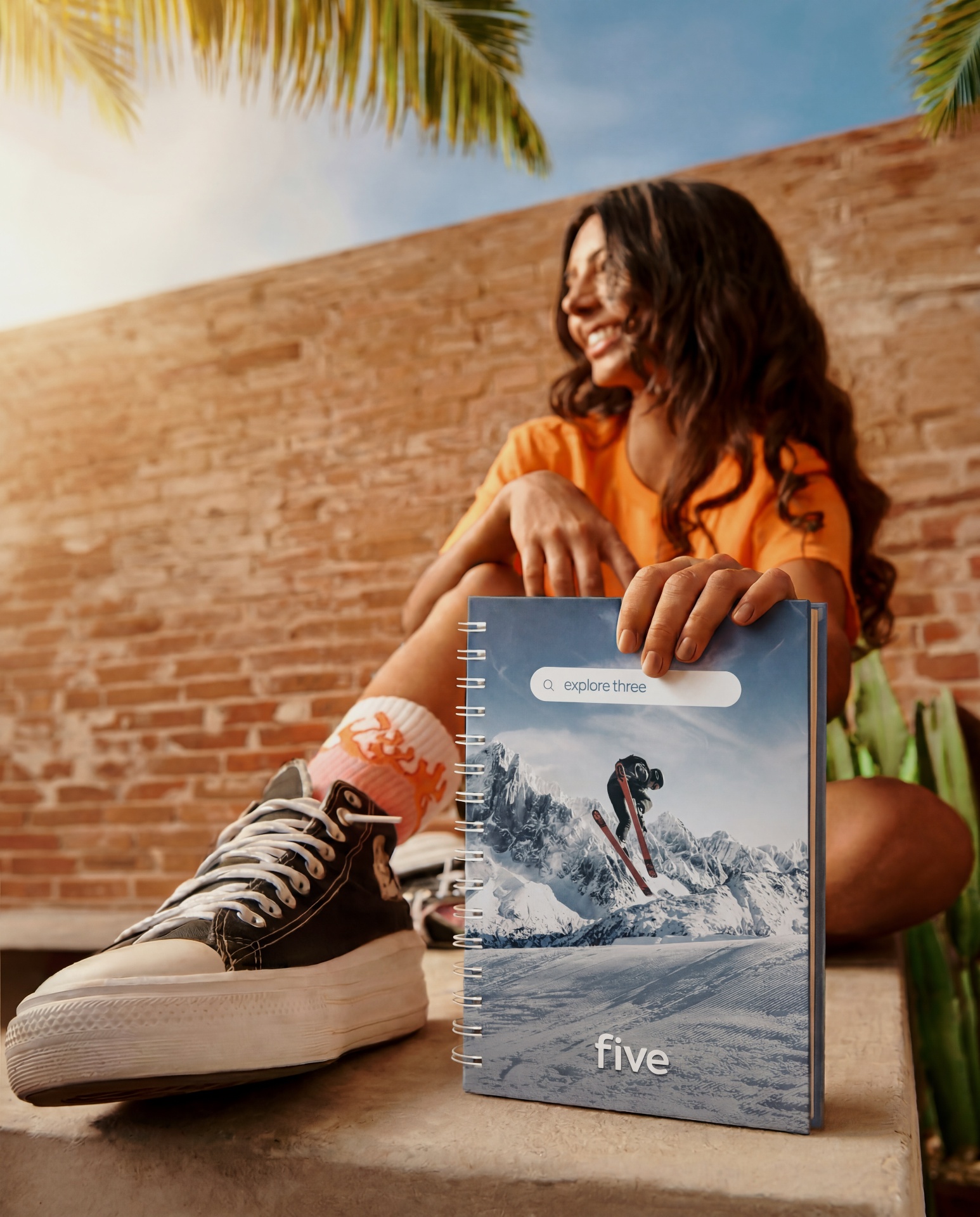 Aluna Five sorrindo com caderno 'explore three' da Five